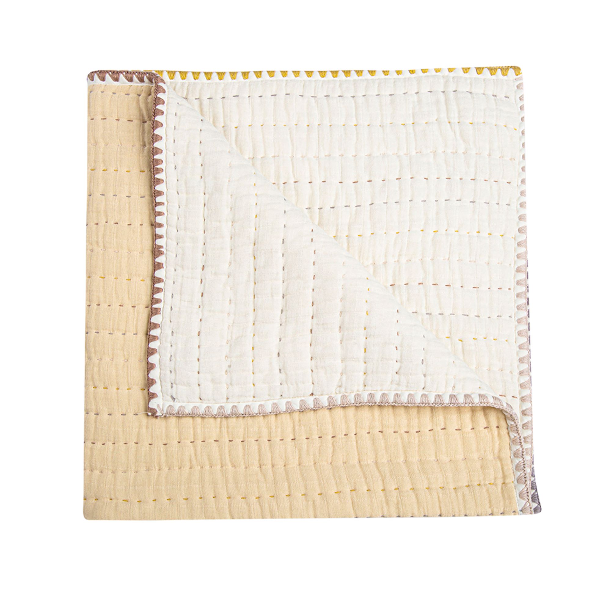 Beige quilted blanket on white background