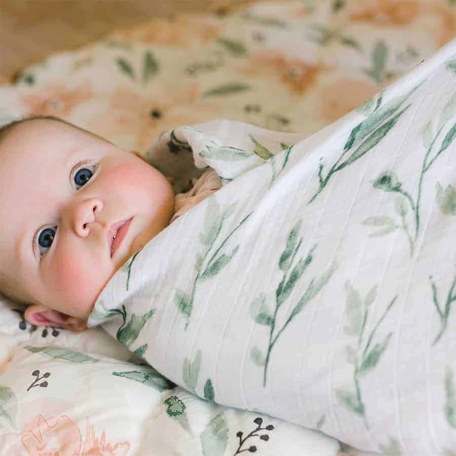 baby being wrapped in a swaddle blanket