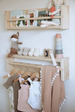 Close up of baby clothes hang on the wall