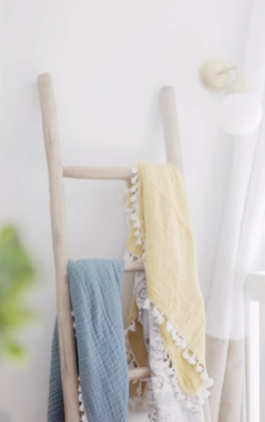 baby blankets displayed on a wooden ladder as decor