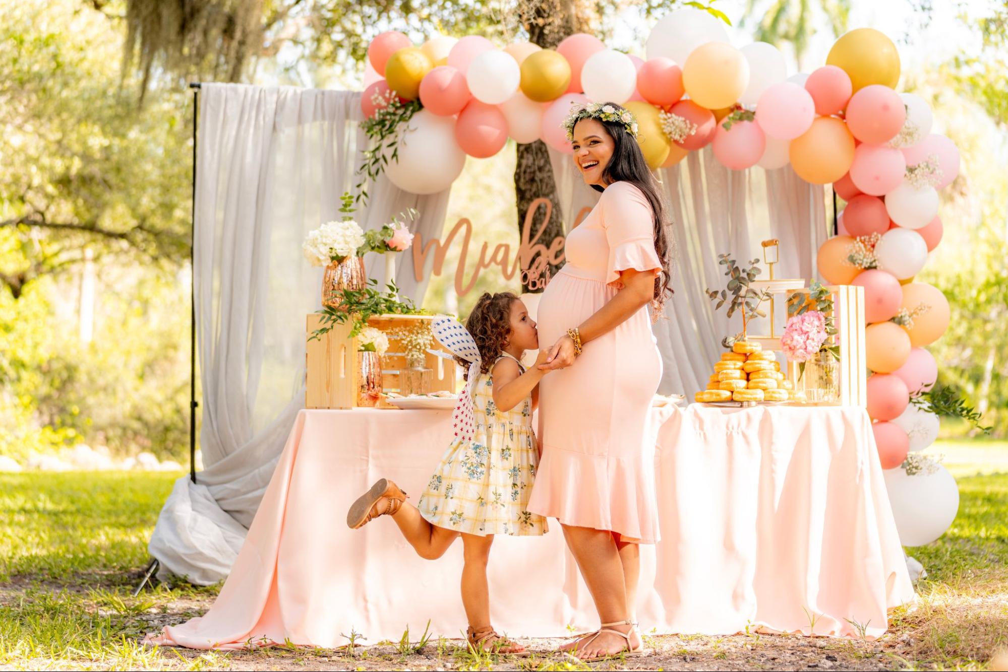 Daughter kissing mom's belly at a baby shower