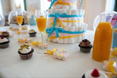 Table with drinks, cupcakes and a diaper cake