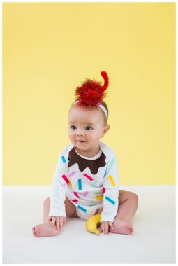 Sitting baby wearing a confetti sundae costume
