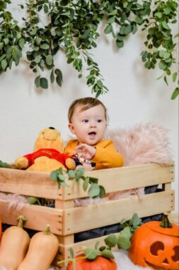 Baby and Winnie the Pooh stuffed bear in a wooden crate