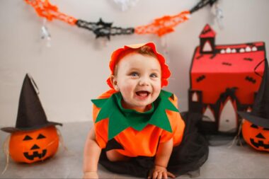 Smiling baby wearing a pumpkin costume