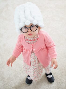 Baby wearing an old lady costume with a white wig
