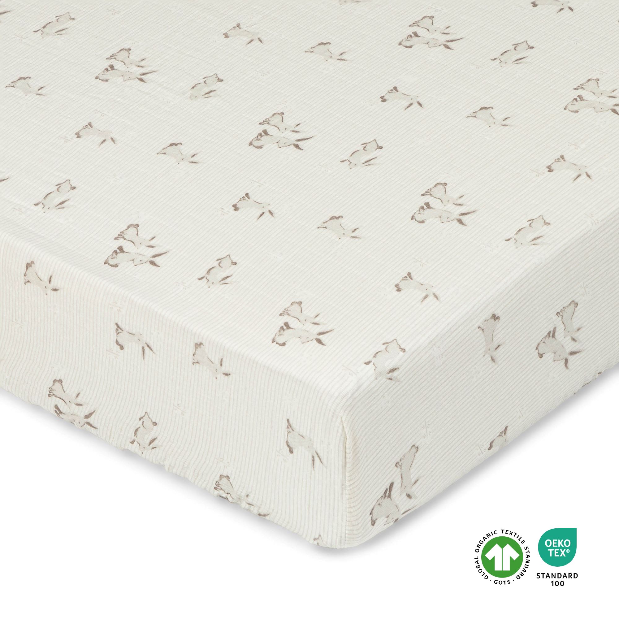 A cream colored crib sheet with bunny designs