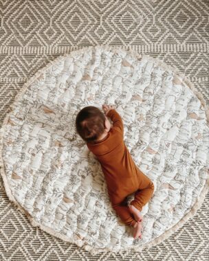 Baby crawling on a play mat