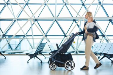 Mom carrying baby and walking through airport