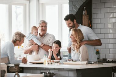 Grandparents, parents and their kids hanging around the kitchen island.