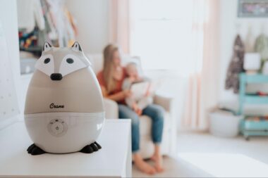 Mom reading to her baby in the background of a baby humidifier