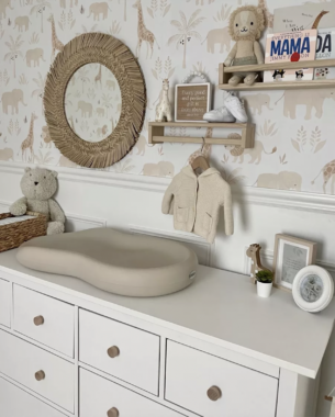 Diaper changing table against a wall with safari animals wallpaper
