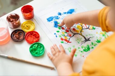 Close up of a baby finger painting a tree