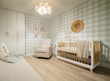Safari themed baby nursery with crib and glider in corner