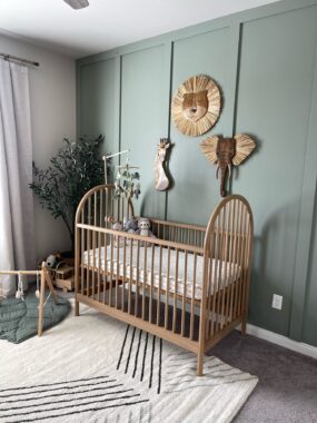 Wooden crib against a wall with animal wall decor 