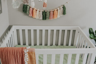 Tassel wall decor above a crib