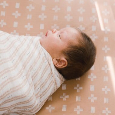 Close up of a baby wrapped in a swaddle blanket