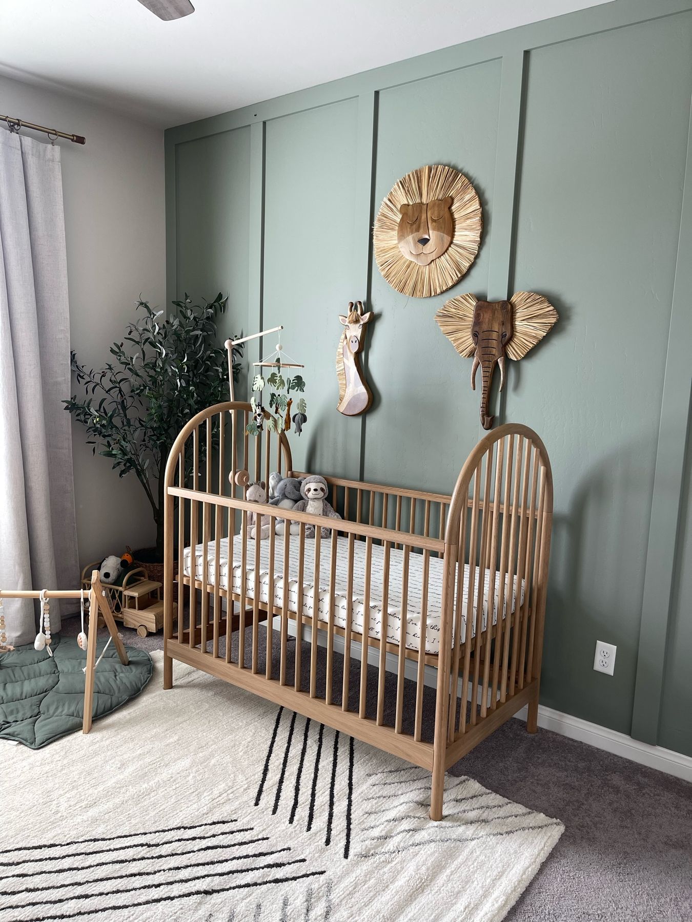 Wooden safari animals wall art above a wooden crib