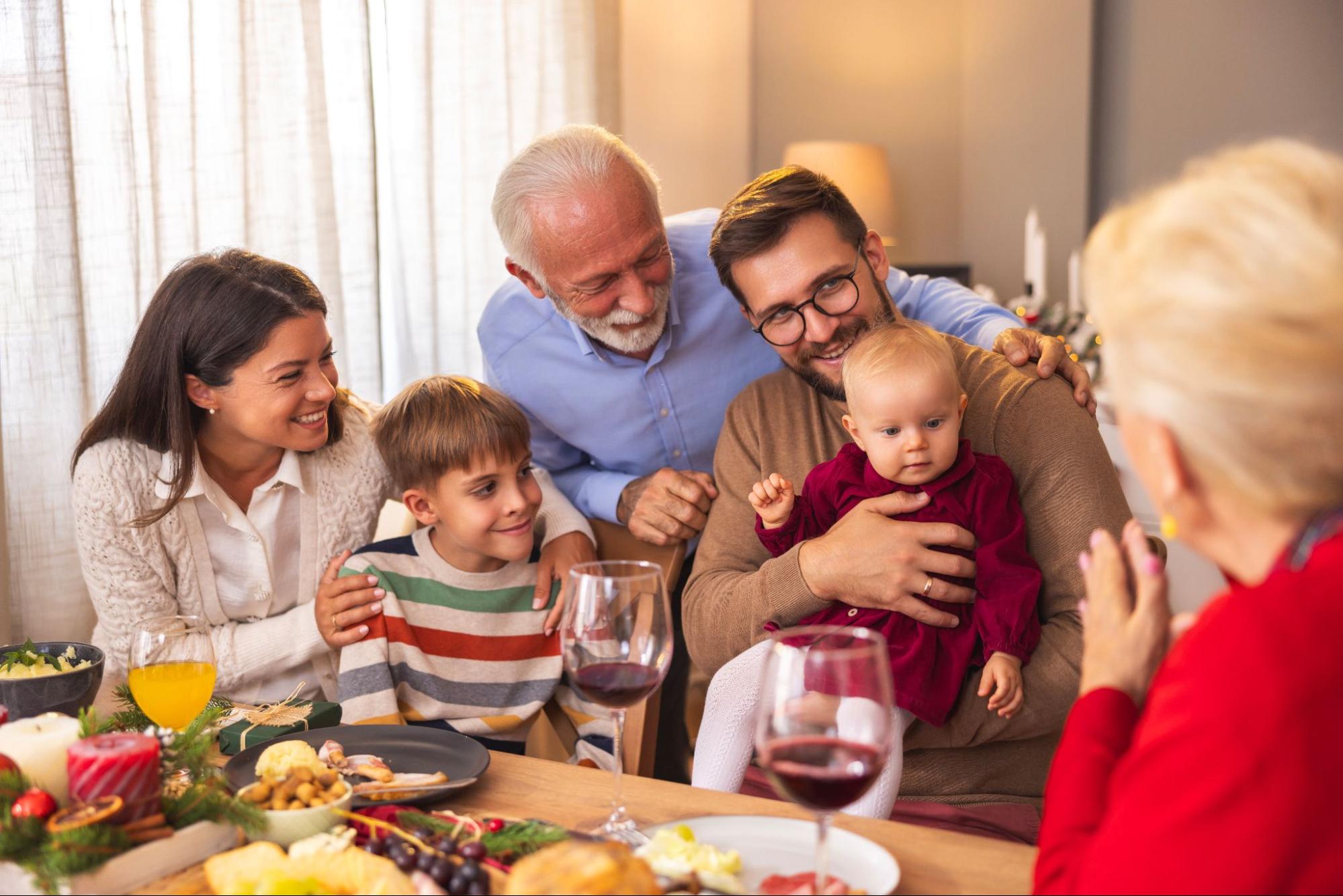Grandmother taking a photo of her family during dinner