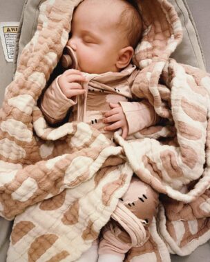 Sleeping baby with a pacifier wrapped in a blanket
