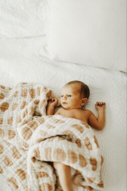 Baby lying down with a baby blanket 