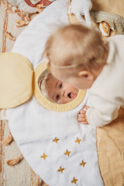 Baby doing tummy time while looking into a mirror