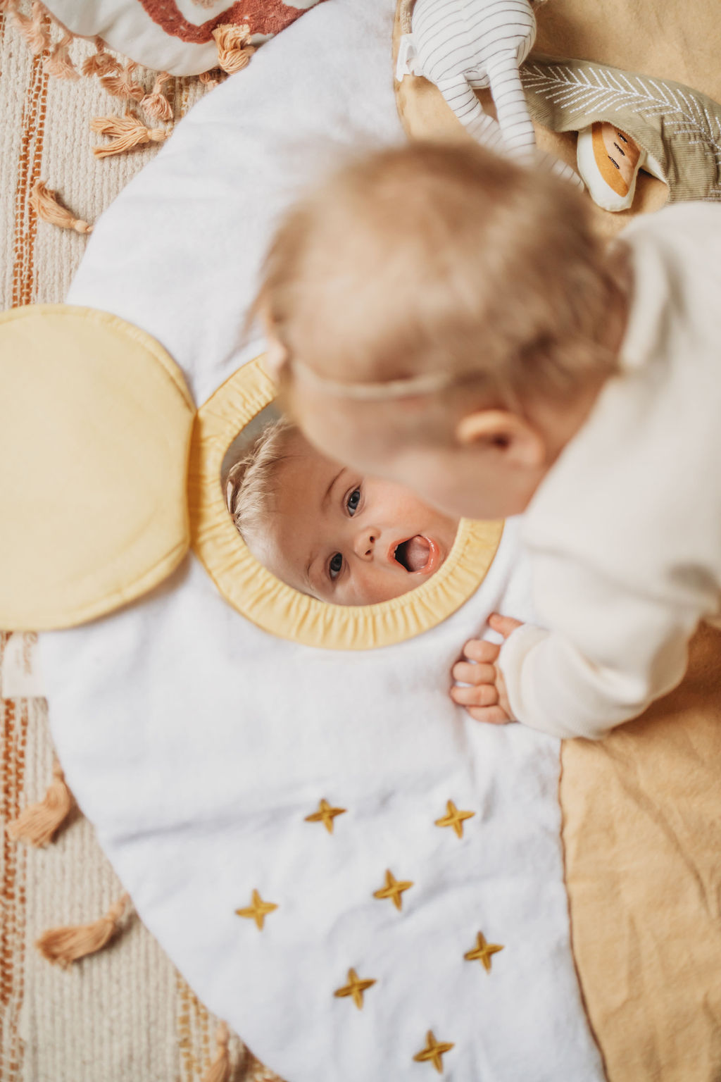 Baby doing tummy time while looking into a mirror