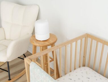 Humidifier on a stool in between a crib and a rocking chair