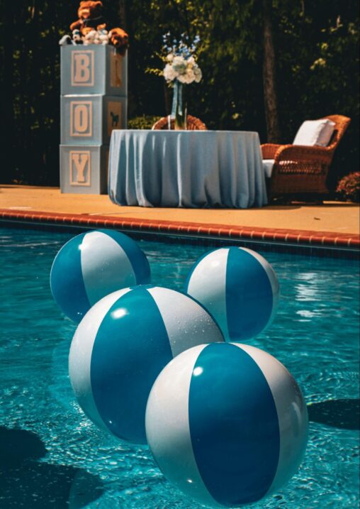 Boy baby shower decorations and table next to a pool