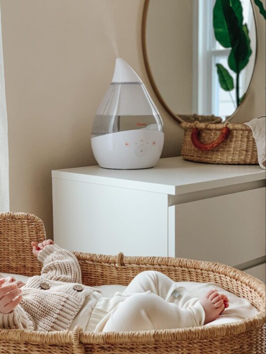 Humidifier on a dresser near a baby in a bassinet