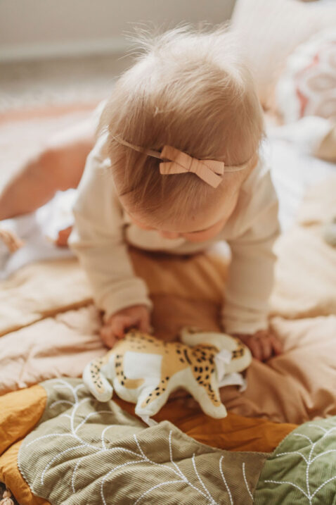 Baby girl playing with a safari activity play mat