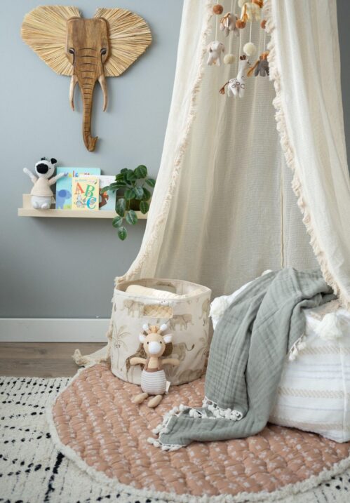 Cozy corner in nursery with a playmat and canopy