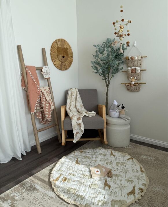 Corner of a nursery decorated with wall decor and a blanket ladder