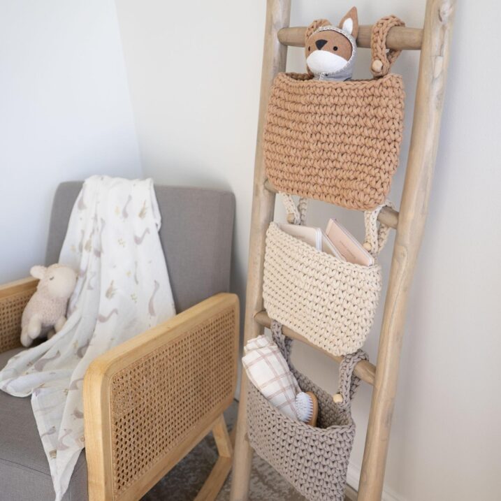 Hanging nursery storage trio on a ladder full of baby supplies