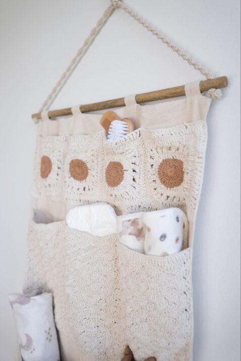 Close up of a wall storage organizer holding diaper supplies