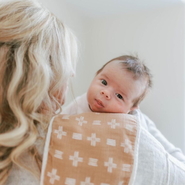 Mom burping her baby with a burp cloth over her shoulder